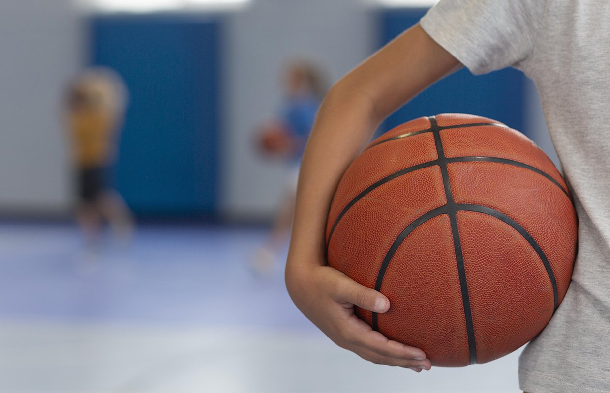Kind hält Basketball in der Hand